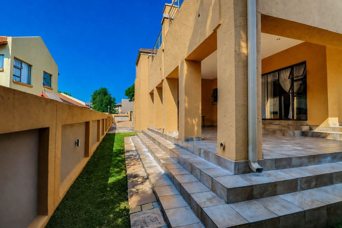 A spacious rear patio featuring tiled flooring, recessed lighting, and direct access to the interior through large sliding glass doors.