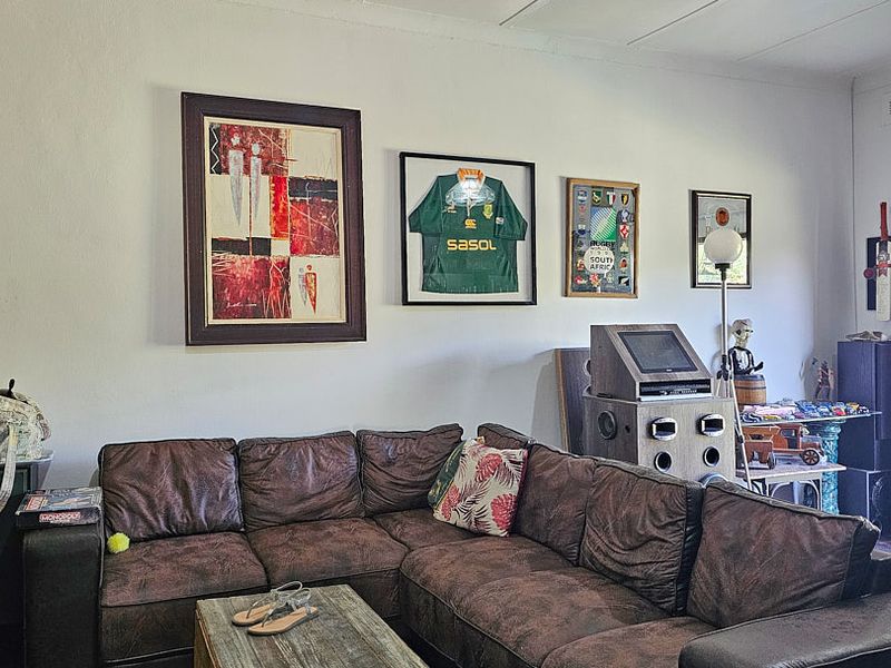 A comfortable living room area featuring neutral walls and a sliding door providing access to the outdoor space.