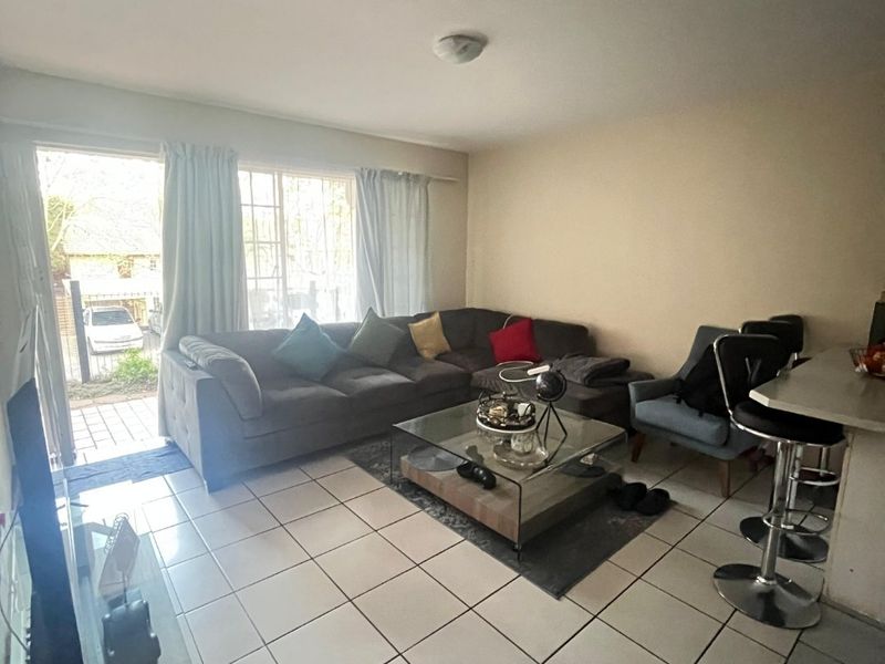 Open plan living area featuring tiled flooring and a sliding glass door providing access to the exterior.