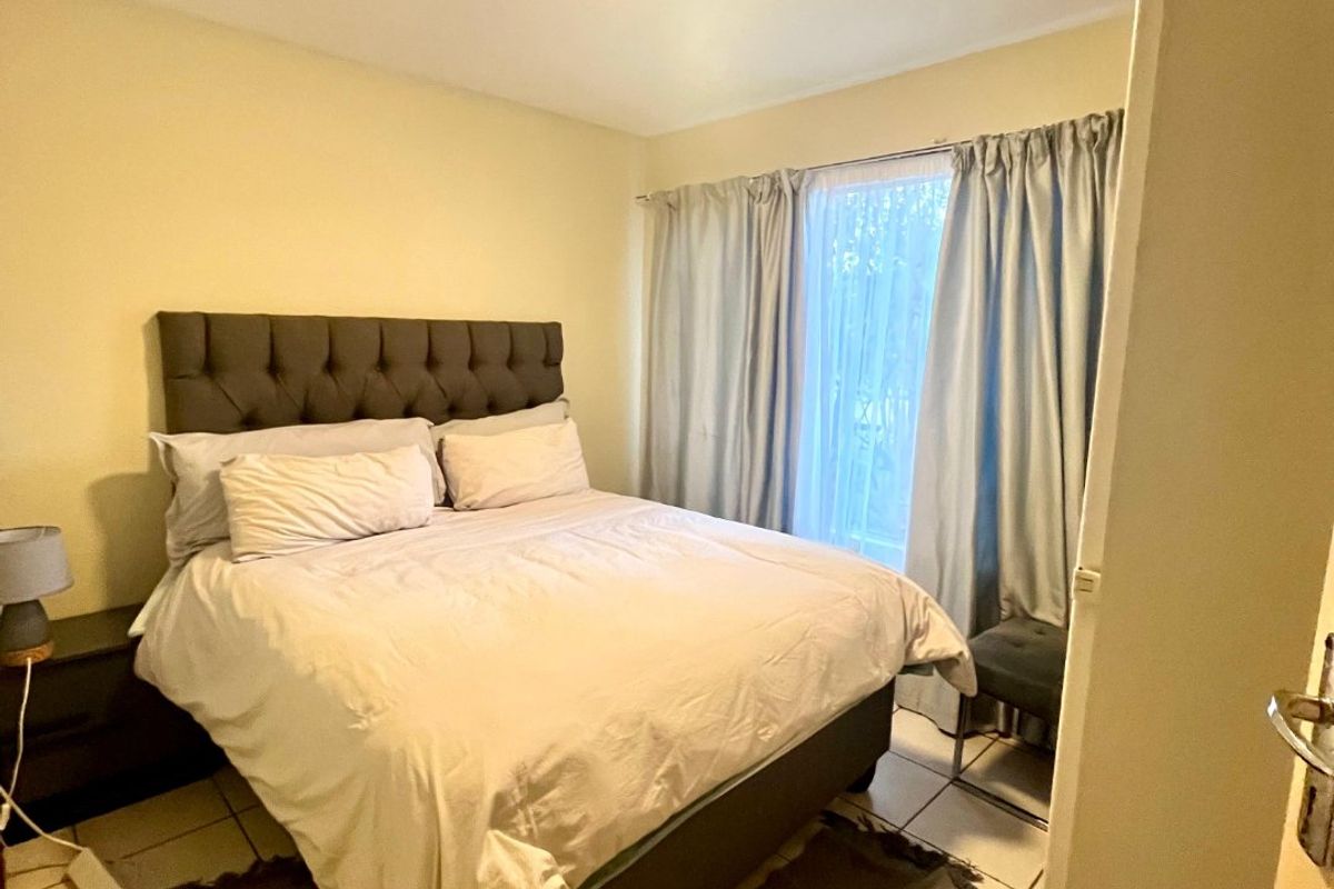 A functional bedroom featuring tiled flooring and a central ceiling light fixture, providing a neutral space ready for personalization.