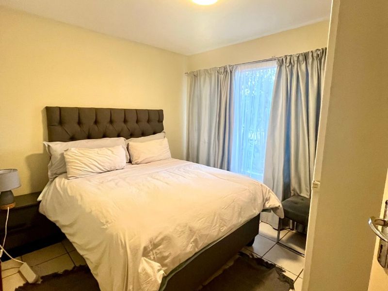 A functional bedroom featuring tiled flooring and a central ceiling light fixture, providing a neutral space ready for personalization.