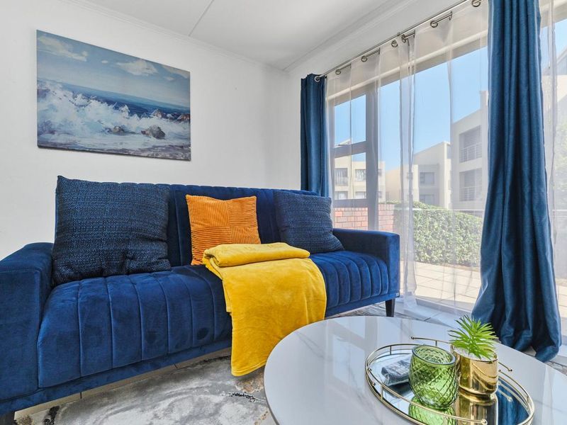 A bright living room featuring large sliding glass doors that provide natural light and access to the exterior patio area.