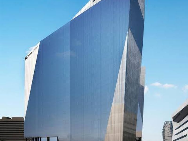A modern commercial high-rise building featuring a striking glass curtain wall facade and contemporary architectural design.