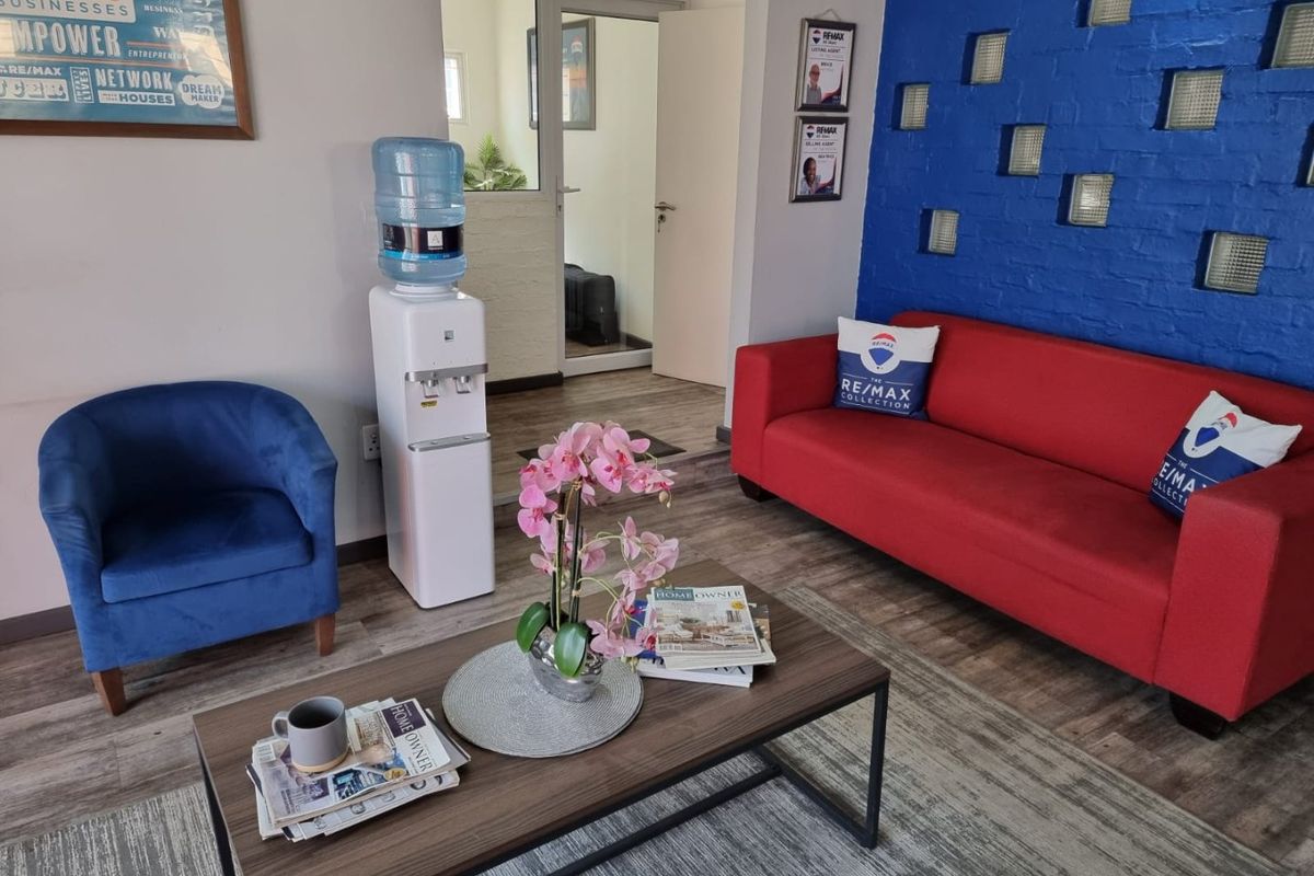 A commercial reception or waiting area featuring a distinctive blue brick wall with glass block inserts and durable laminate flooring.