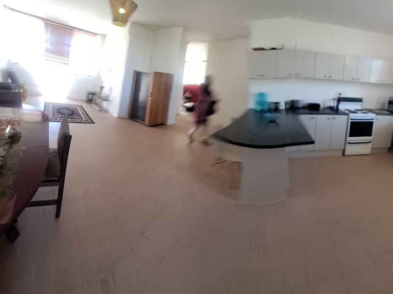 Open plan living and kitchen area featuring tiled flooring, kitchen cabinetry, and a central island.