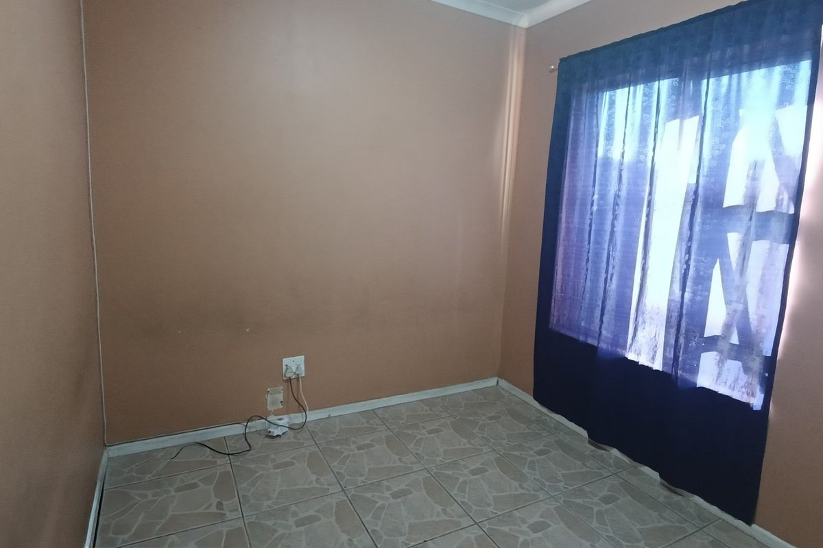 An empty bedroom featuring tiled flooring and neutral wall paint, offering a blank canvas for potential interior design updates.