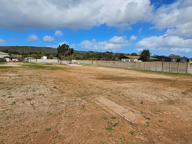A large, open industrial plot featuring a level earth surface enclosed by precast concrete boundary walls.