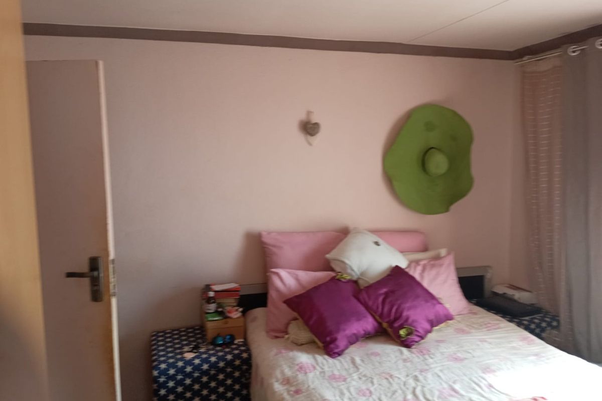 A standard bedroom featuring neutral wall finishes, an internal door, and window treatments.