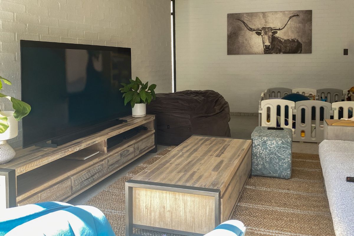 A living room featuring painted brick walls and neutral flooring, providing a versatile space for relaxation and family activities.