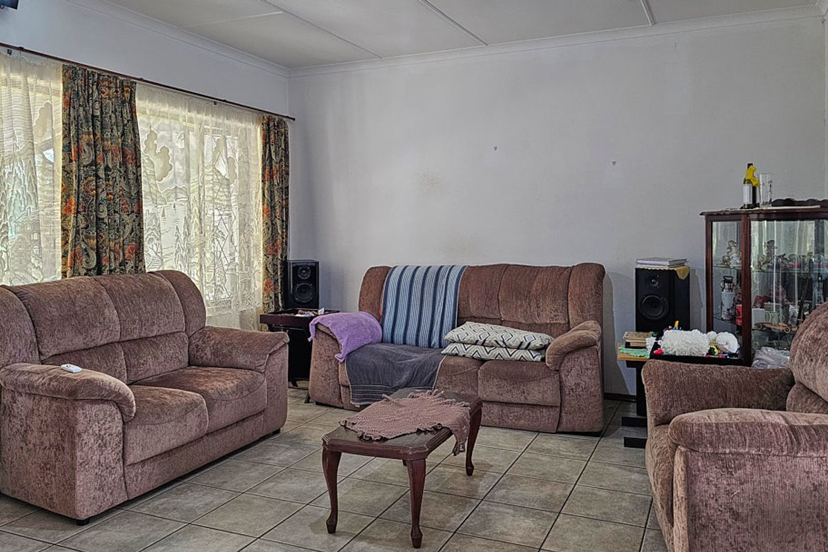 A living room featuring tiled flooring and a coved ceiling, providing a neutral base for potential interior updates.