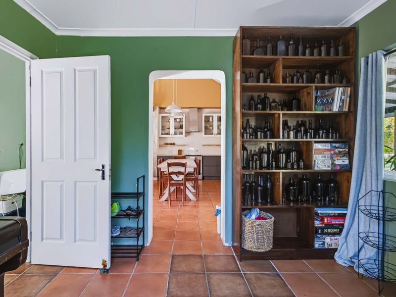 Open plan living area featuring terracotta floor tiles and a classic archway leading into the kitchen space.