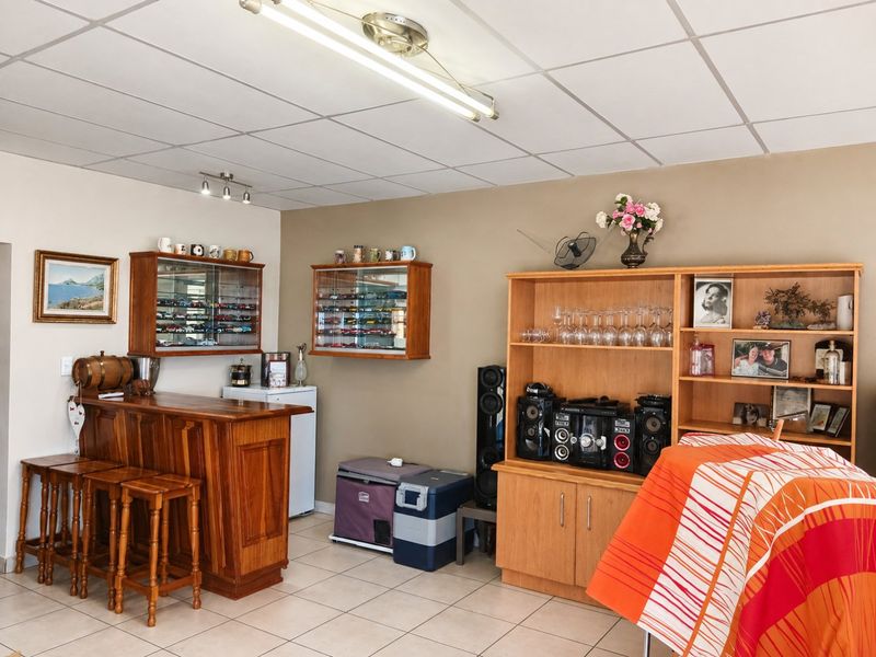 A dedicated bar area featuring a built-in wooden counter, tiled flooring, and a drop ceiling, providing a functional space for entertainment.