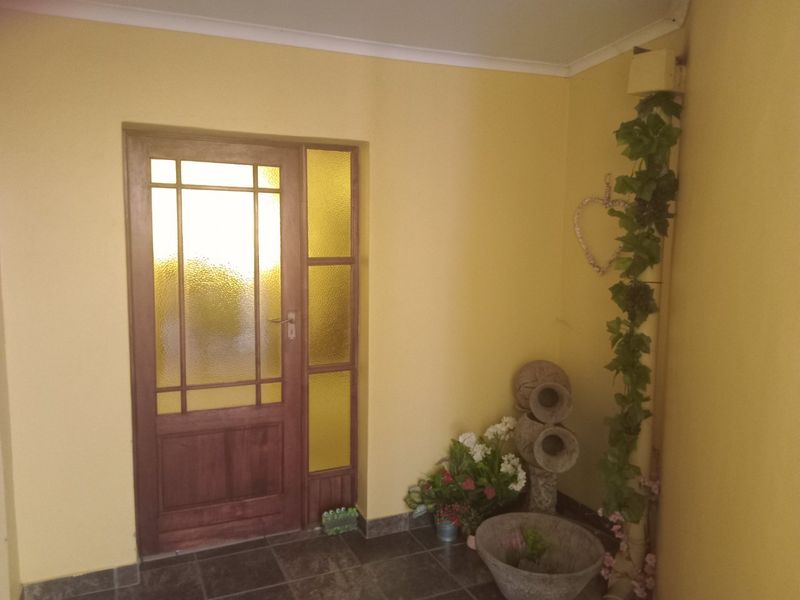 A bright entrance area featuring a timber-framed glass door and tiled flooring, providing a welcoming transition into the home.