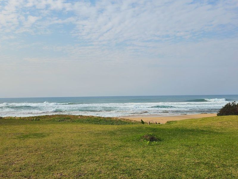 A scenic view of the ocean and coastline from the property grounds, showcasing natural landscape and beach access.