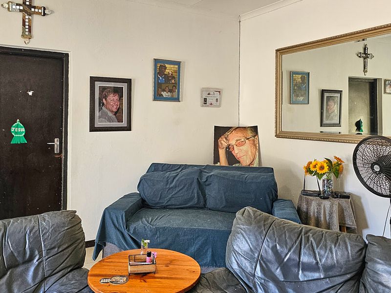 A living room area featuring neutral walls, a large wall-mounted mirror, and a standard internal door.