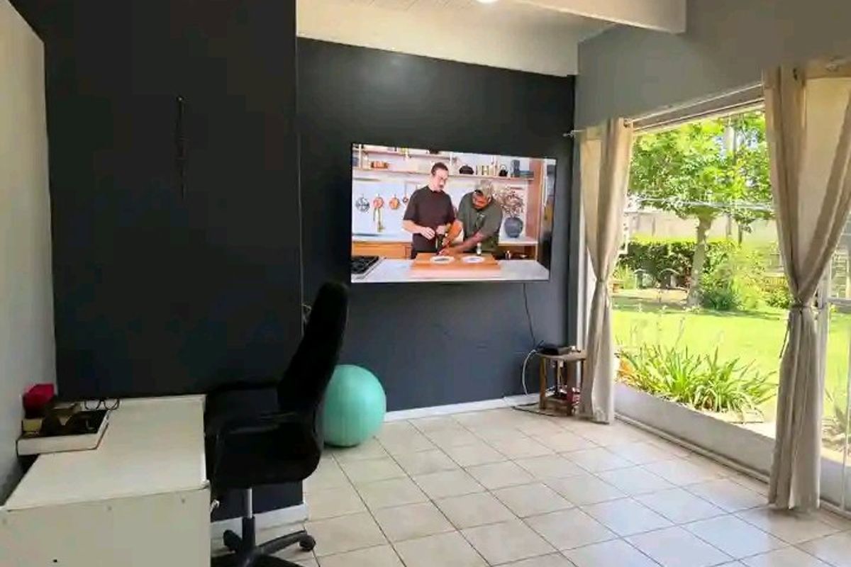 A living area featuring tiled flooring and a large sliding glass door providing direct access to the garden.