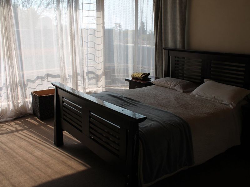 A bedroom featuring carpeted flooring and a large sliding glass door that allows for natural light.
