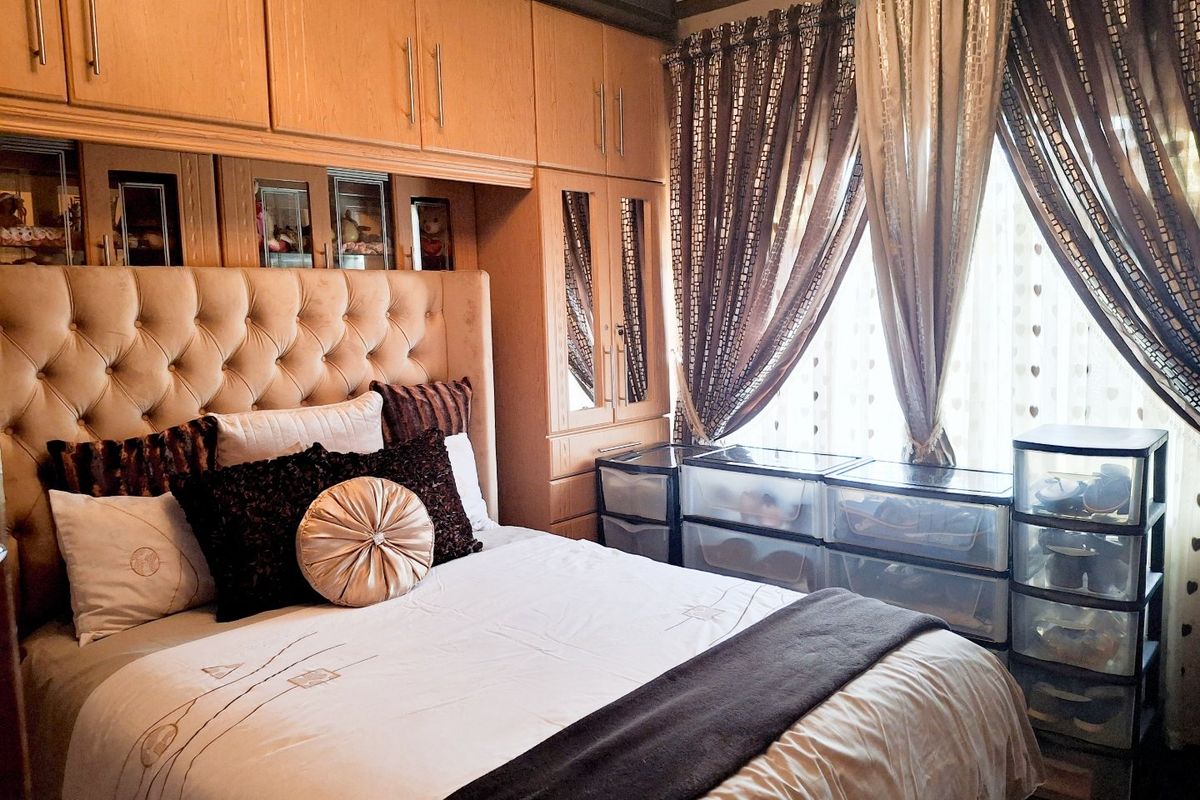 A bedroom featuring extensive built-in wooden cabinetry with integrated mirrored doors, providing ample storage space.