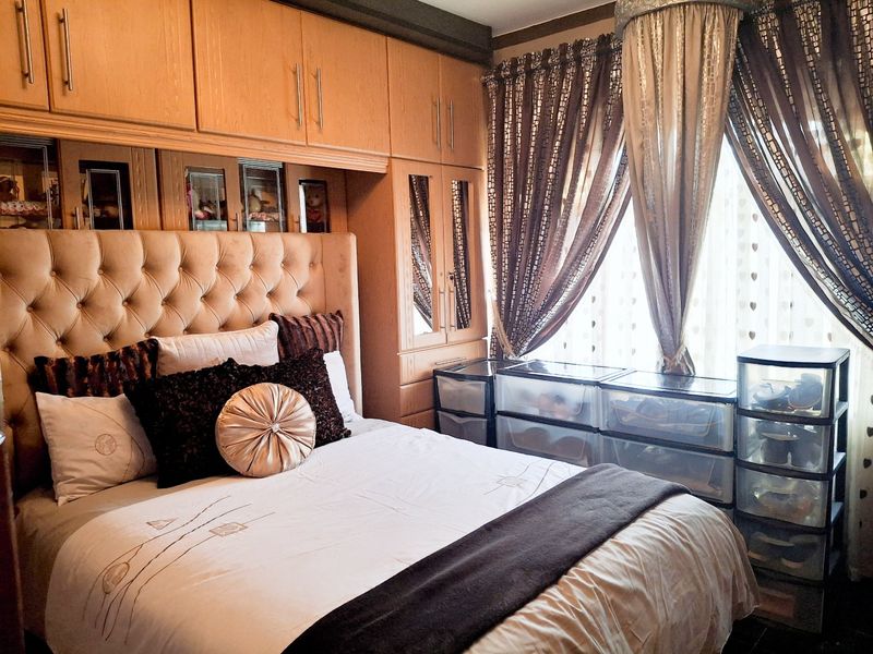 A bedroom featuring extensive built-in wooden cabinetry with integrated mirrored doors, providing ample storage space.