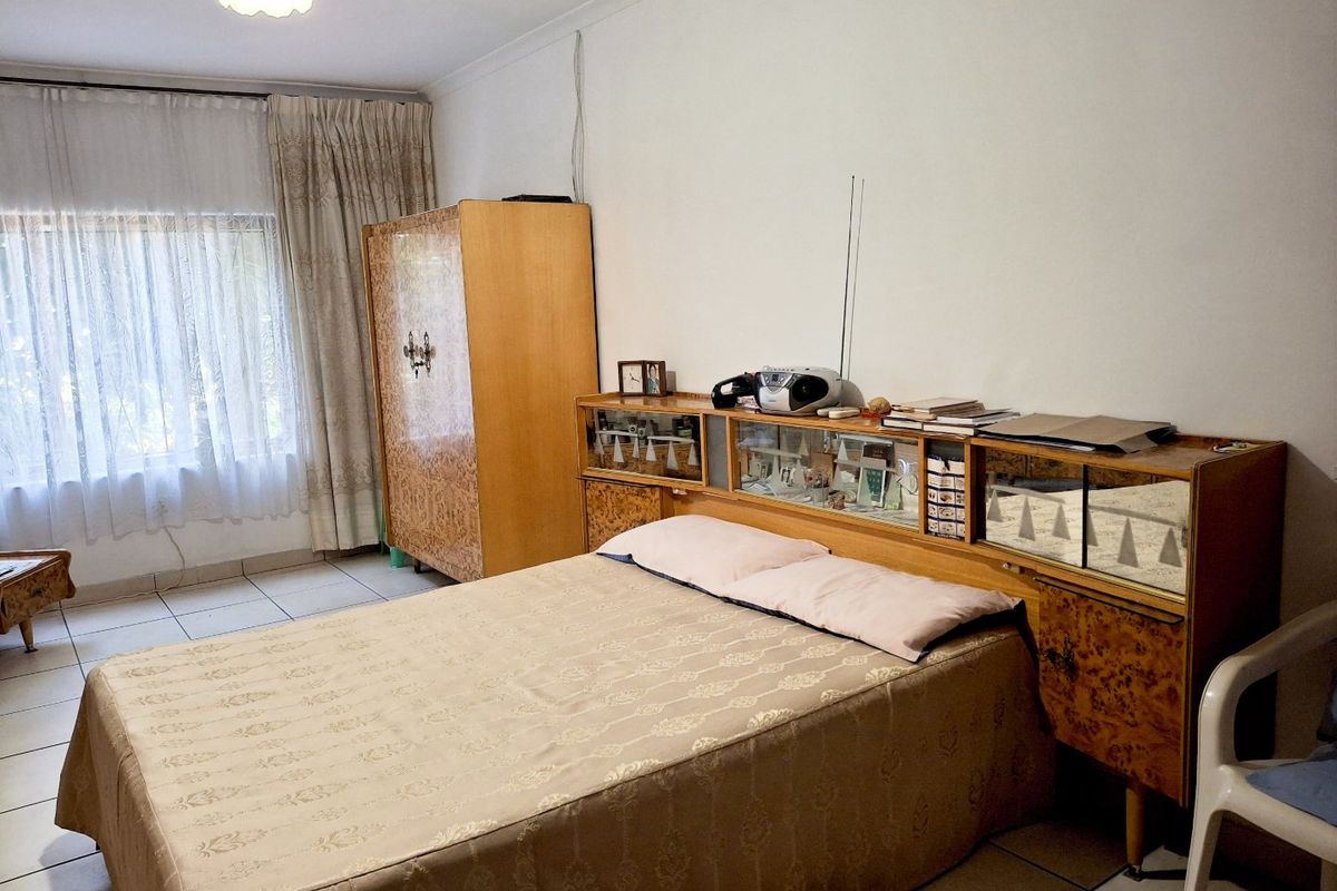 A bedroom featuring tiled flooring and standard ceiling finishes, offering a functional space with neutral wall tones.