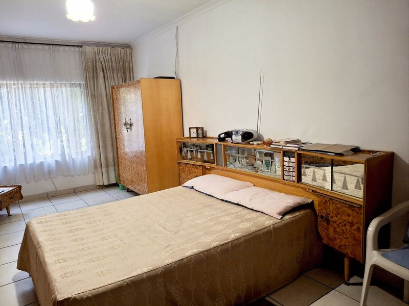 A bedroom featuring tiled flooring and standard ceiling finishes, offering a functional space with neutral wall tones.