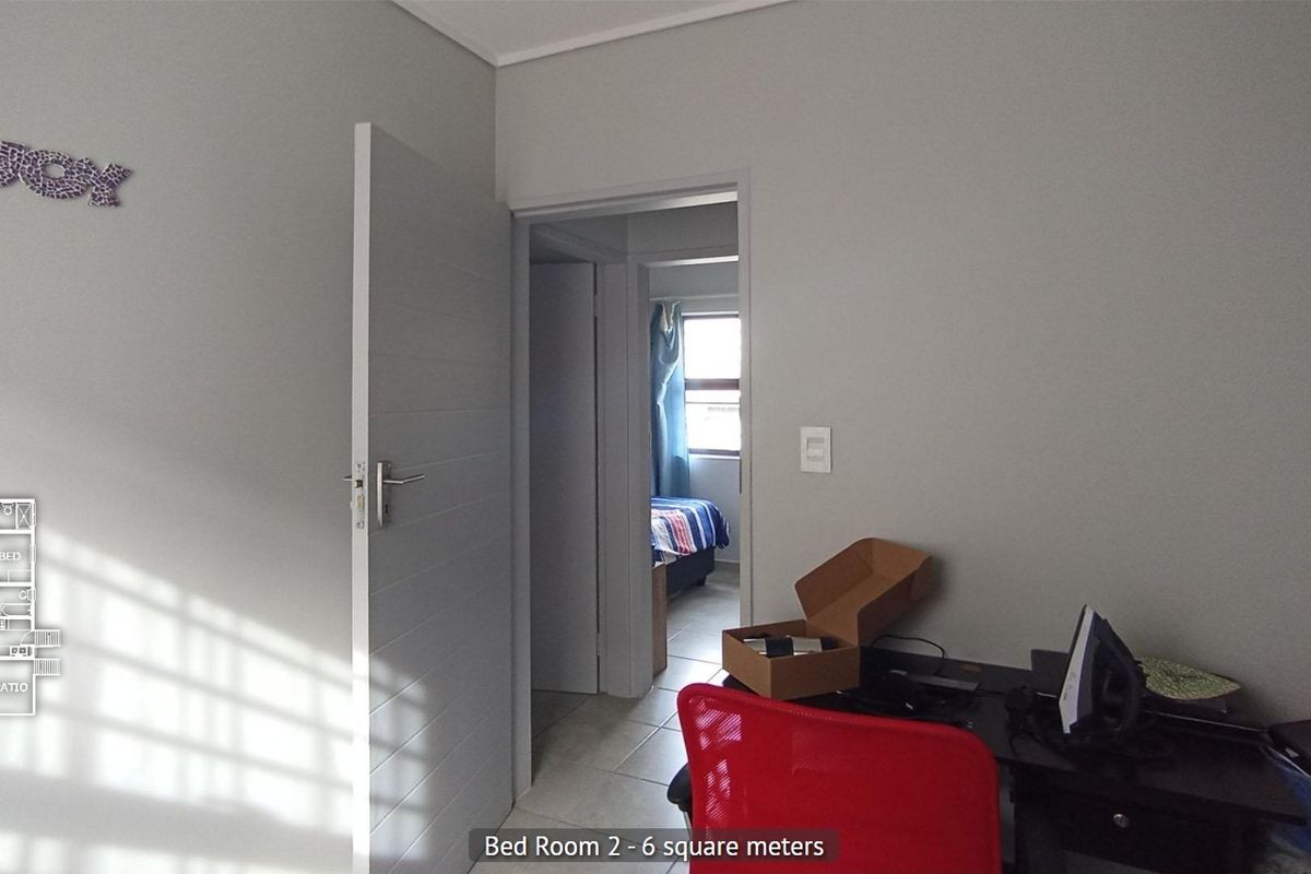 A view of a bedroom featuring tiled flooring and an internal door, with a glimpse into the adjacent room.
