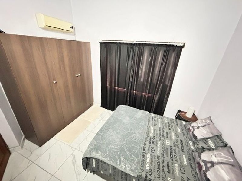 A bedroom featuring tiled flooring, a built-in wardrobe, and a wall-mounted split-system air conditioning unit.