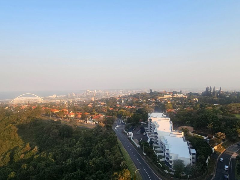 An elevated panoramic view overlooking the surrounding urban landscape, coastal area, and local infrastructure.