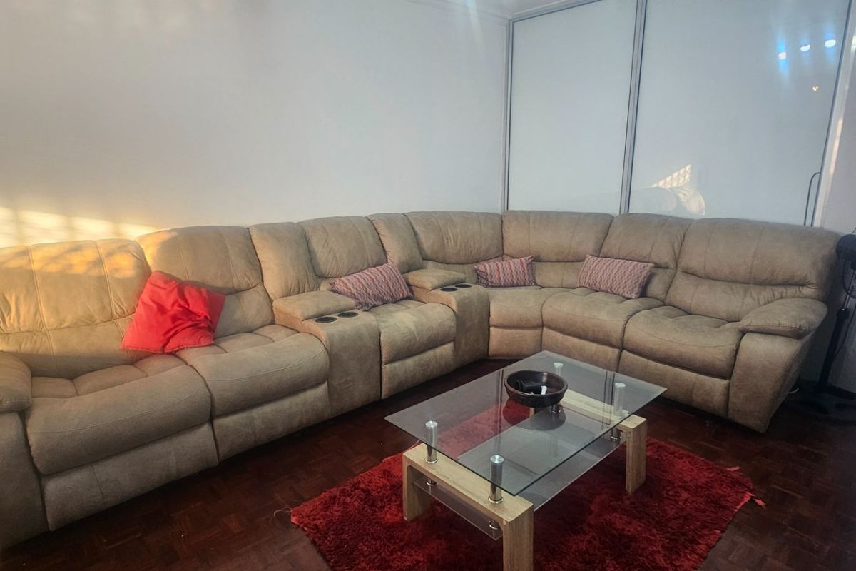 A living room featuring dark parquet flooring and a large built-in sliding door wardrobe, providing ample storage space.