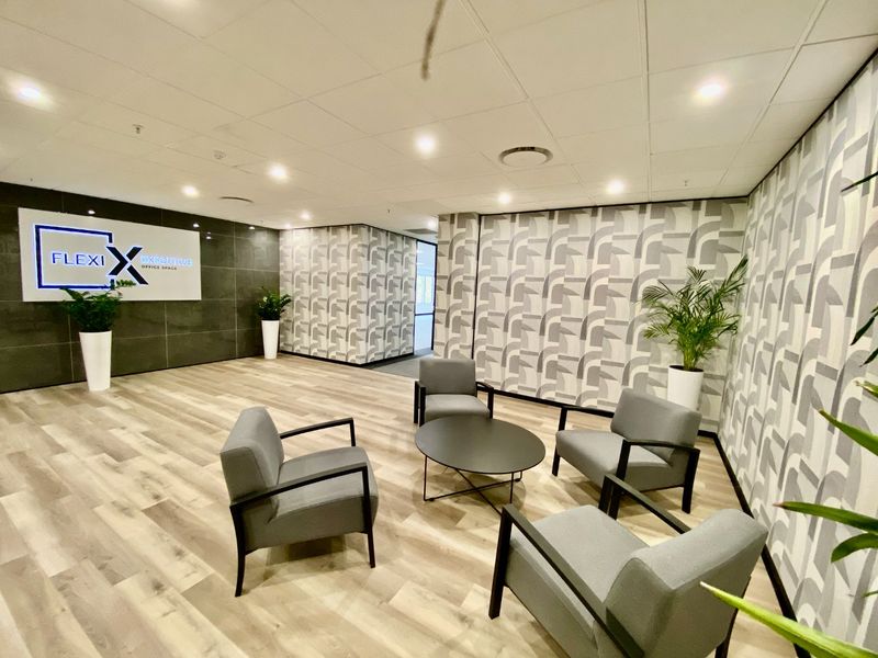Modern commercial office reception or waiting area featuring contemporary laminate flooring, patterned wallpaper, and professional recessed lighting.