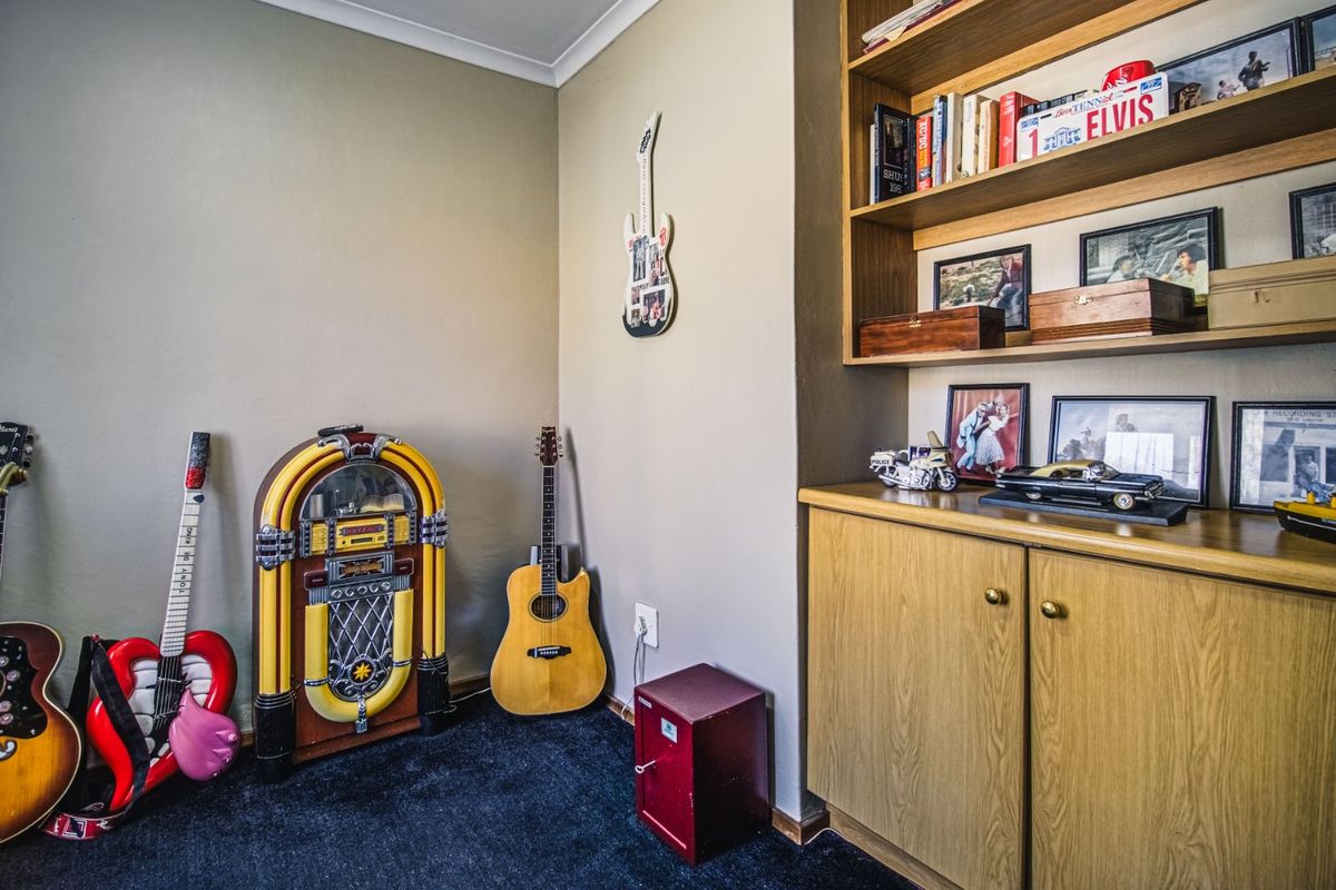 A bedroom space featuring built-in wooden cabinetry and shelving, providing ample storage and display options within the room.