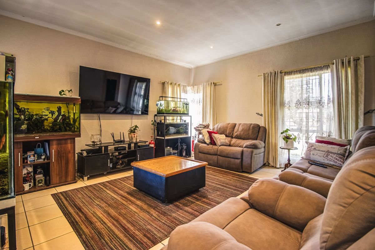 A comfortable living room featuring tiled flooring and recessed downlighting, providing a functional and well-lit space for relaxation.