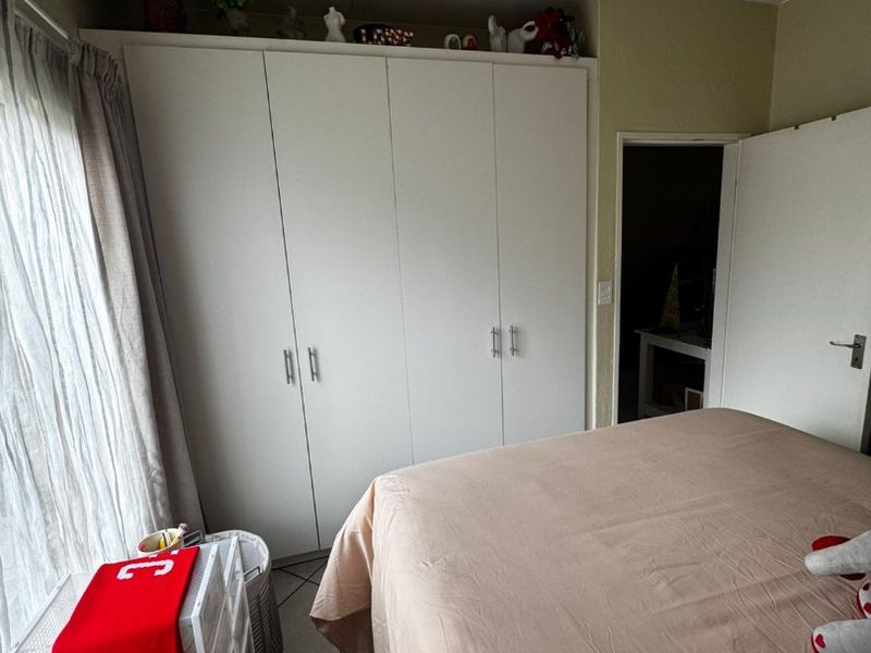 A bedroom featuring built-in cupboards and tiled flooring, providing functional storage space within the apartment.