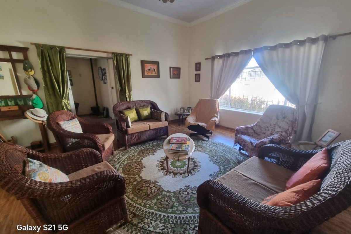 A spacious living room featuring laminate flooring and coved ceilings, offering a comfortable and traditional layout for family relaxation.