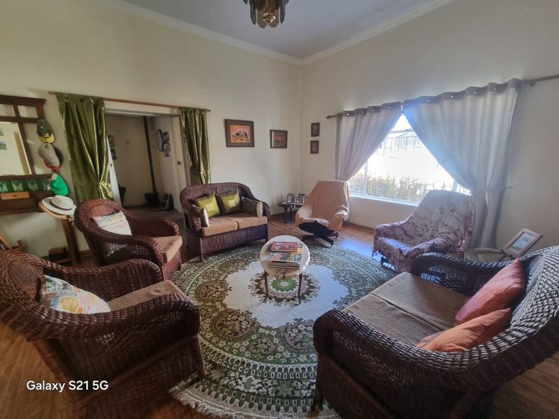 A spacious living room featuring laminate flooring and coved ceilings, offering a comfortable and traditional layout for family relaxation.