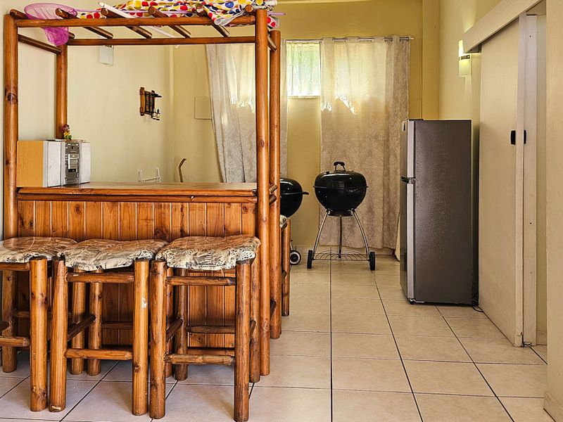 A dedicated bar area featuring a built-in wooden counter and tiled flooring, providing a functional space for entertainment.