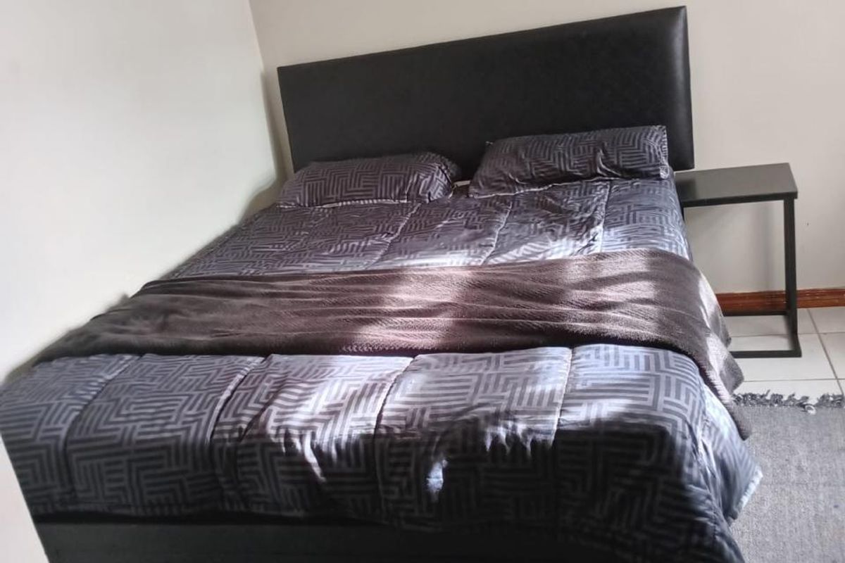 A bedroom featuring neutral wall finishes and tiled flooring, providing a functional and clean space for rest.