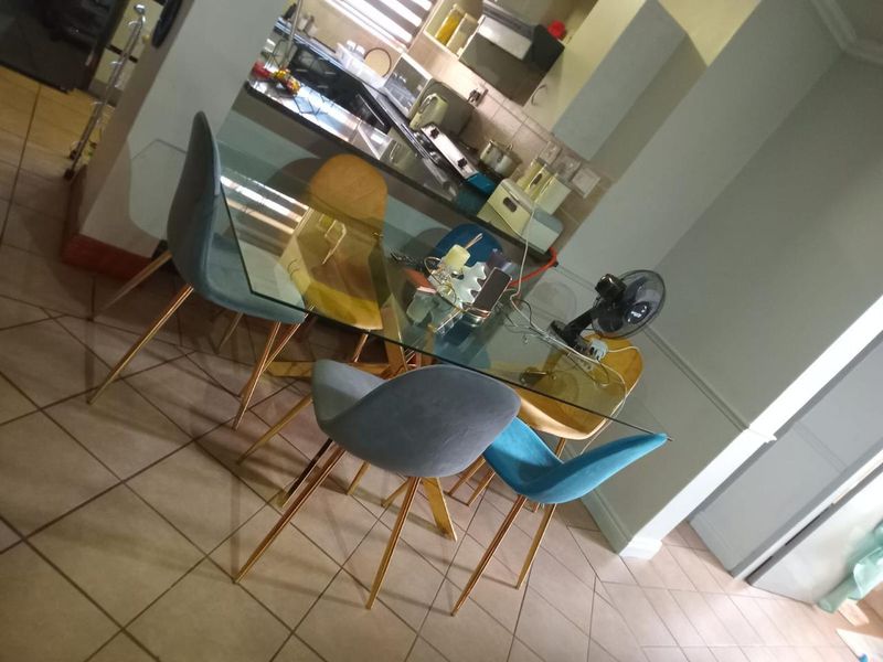 Open plan dining area adjacent to a functional kitchen with tiled flooring and built-in cabinetry.
