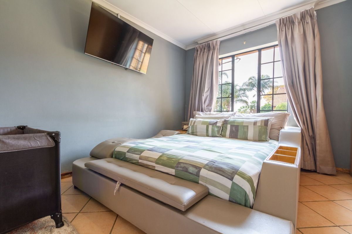 A bedroom featuring tiled flooring, a window with security bars, and coved ceiling details.