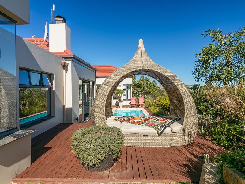 A well-maintained outdoor pool area featuring timber decking, a swimming pool, and direct access to the home through sliding glass doors.