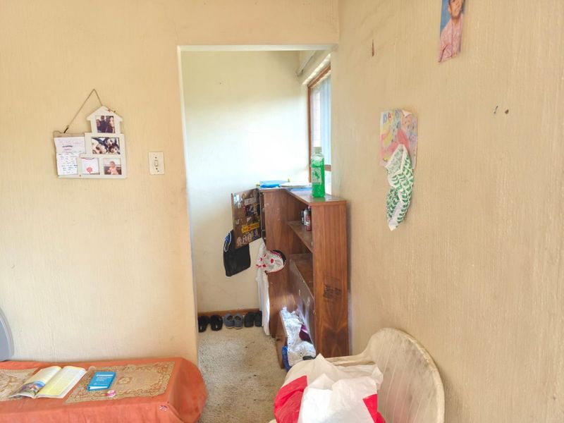 A view through a doorway into a small transition space or hallway with plain wall finishes and a window.