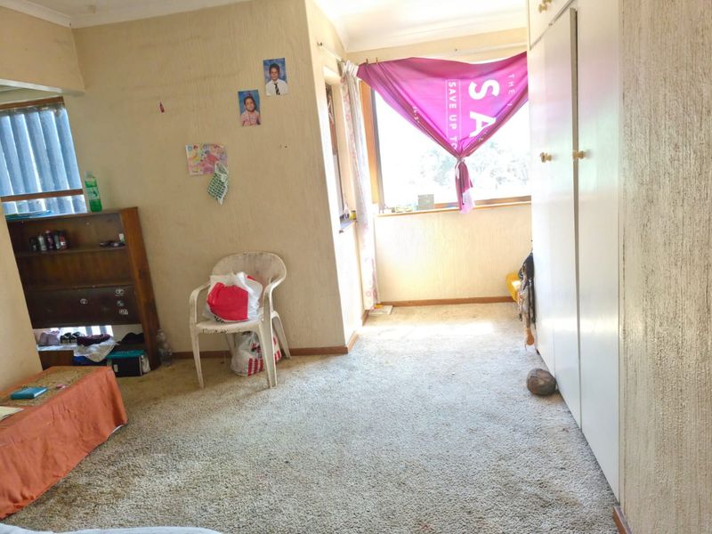 A bedroom featuring built-in cupboards and carpeted flooring, requiring cosmetic updates to improve its overall condition and appeal.