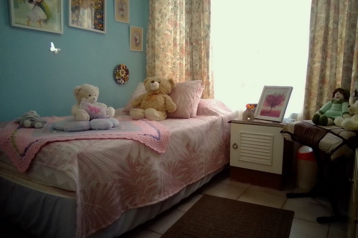 A bedroom featuring tiled flooring and natural light from a window.
