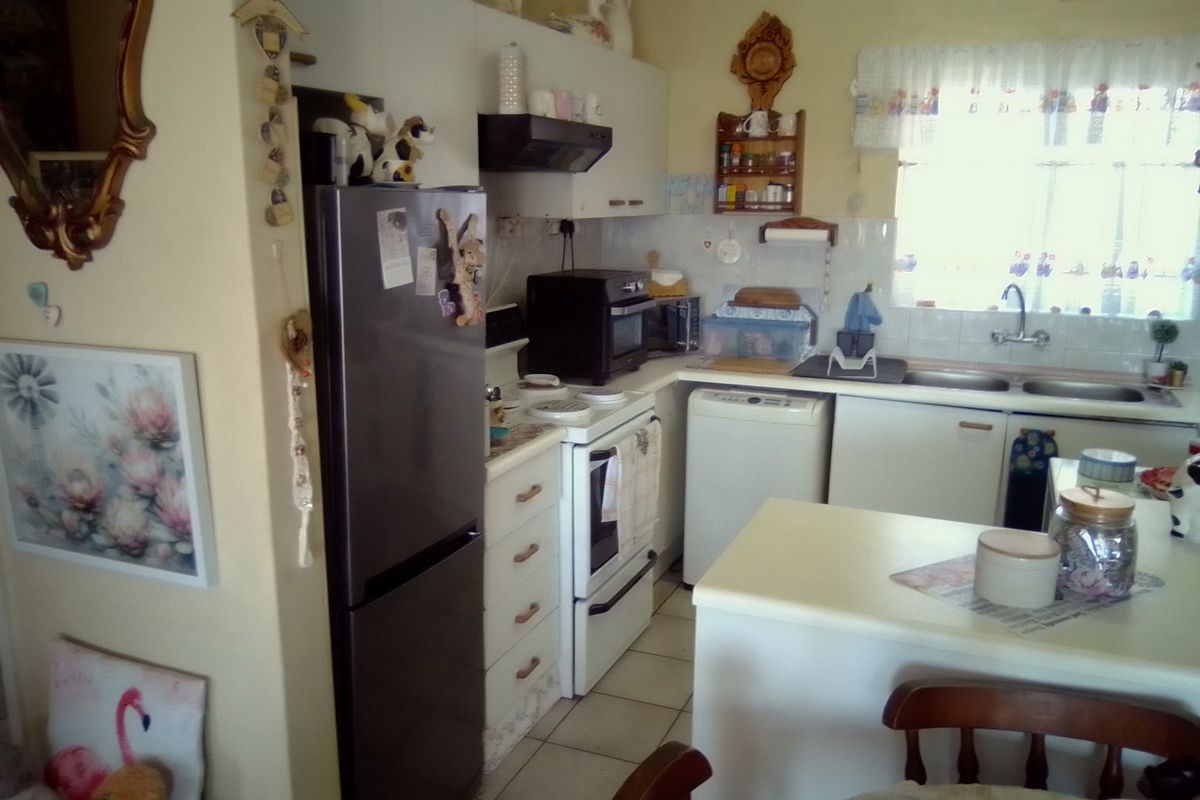 A functional kitchen featuring built-in cabinetry, a double sink, and tiled splashbacks, offering a practical layout for daily meal preparation.