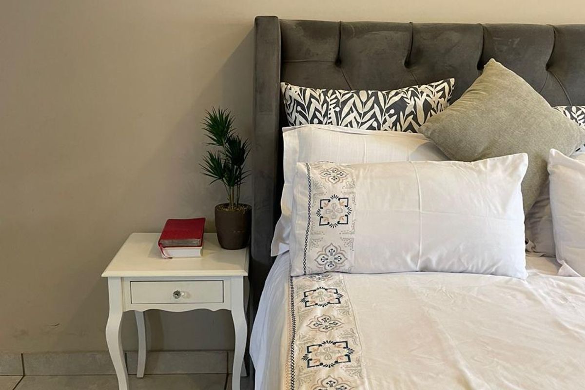 A bedroom featuring tiled flooring and a neutral wall finish, providing a clean and functional space.