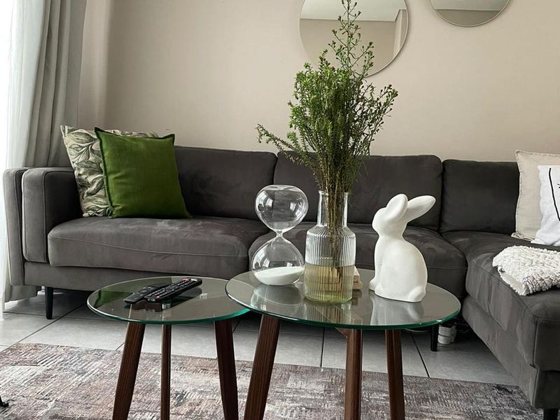 A well-maintained living room featuring neutral wall tones and tiled flooring, creating a comfortable and inviting atmosphere.