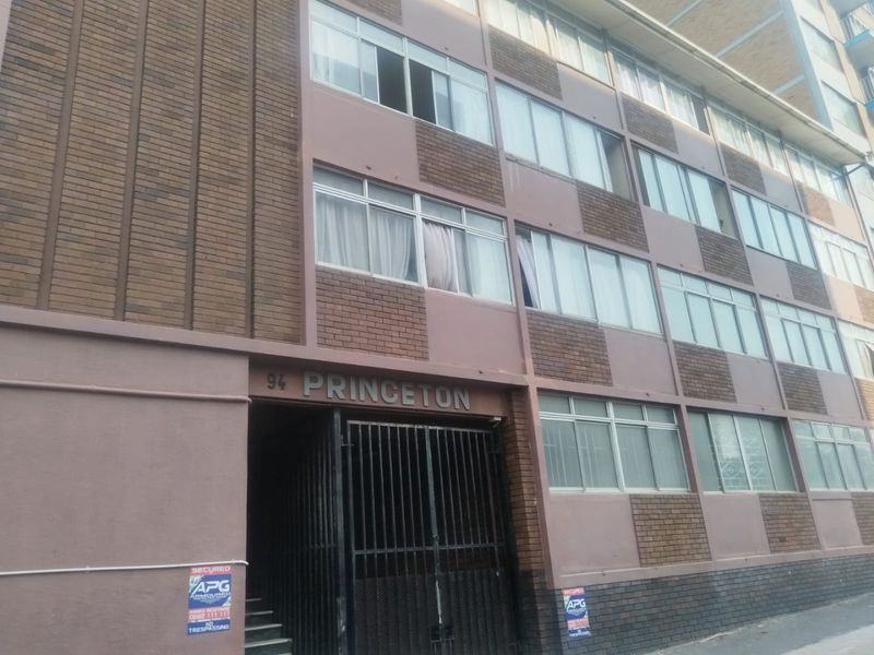 Front elevation of the Princeton apartment building, featuring a brick and painted facade with secure gated entrance and multi-pane window configuration.