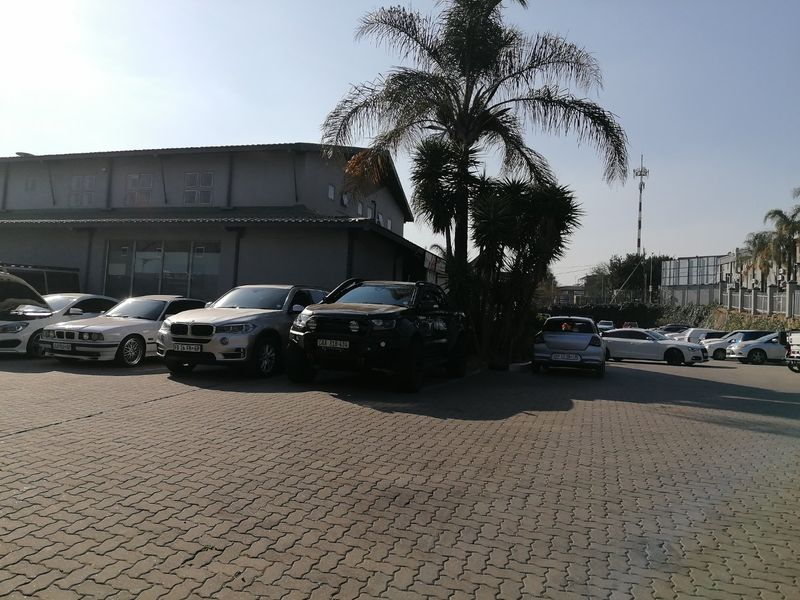 Exterior view of a commercial property featuring a paved parking area and building facade.