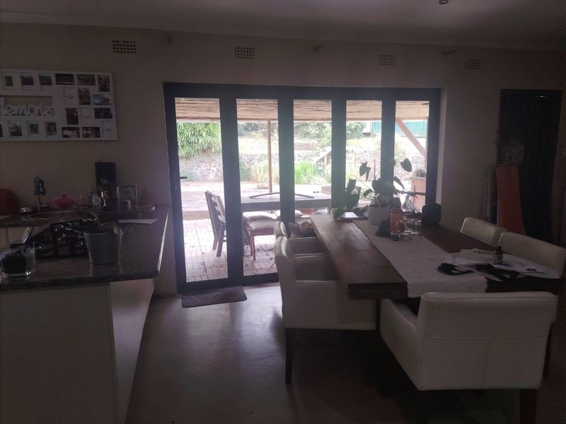Open plan kitchen and dining area featuring granite countertops, a gas hob, and large bi-fold doors providing direct access to the outdoor patio.