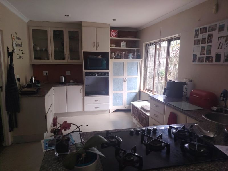 A functional kitchen featuring built-in cabinetry, granite countertops, a gas hob, and a built-in oven with integrated microwave.